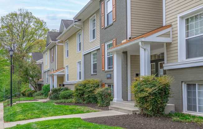 A row of houses with green lawns in front.