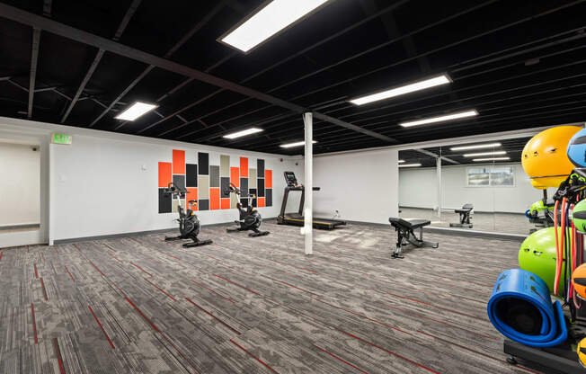 a workout room with exercise equipment and weights in a building with white walls and carpet at Talavera in Boise, ID