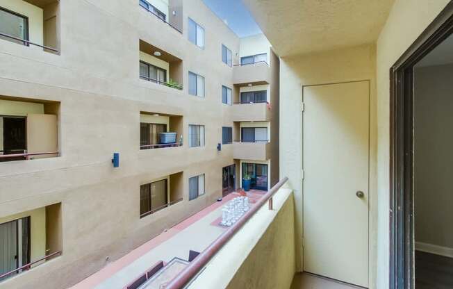 A view of a balcony with a table and chairs on a sunny day.