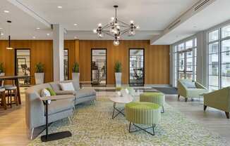 a lobby with couches tables and chairs and a chandelier