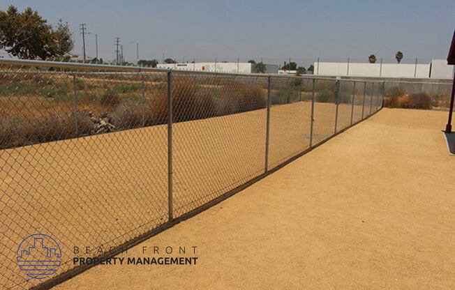 a chain link fence with a dirt path next to it