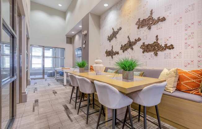 a dining room with a long wooden table and white chairs