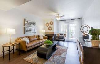 A living room with a brown couch, a coffee table, and a rug.