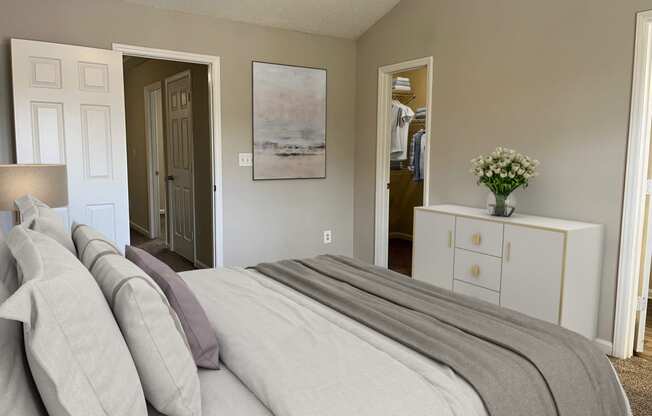 a bedroom with a bed and a dresser and a closet