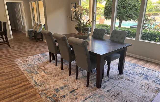 A dining room with a table and chairs.