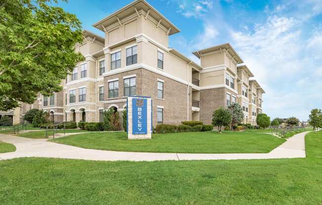 an apartment building with a blue sign in front of it