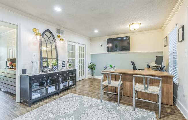 A modern kitchen with a large island and a TV mounted on the wall.
