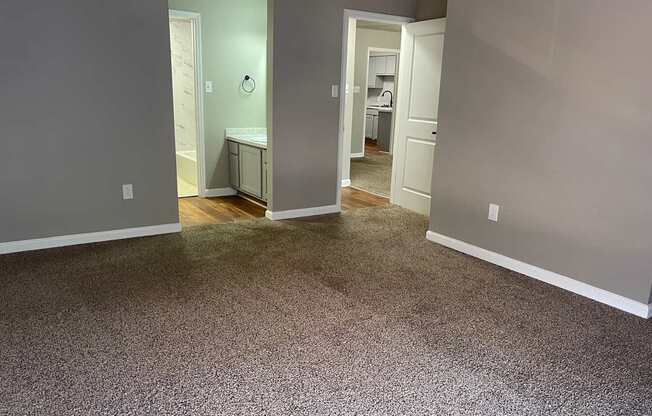 A room with a carpeted floor and a white door.