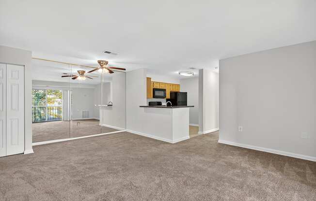 A spacious living room with a ceiling fan and a bar area.