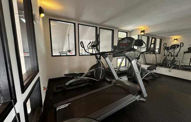 a gym with a treadmill and a workout bike in it