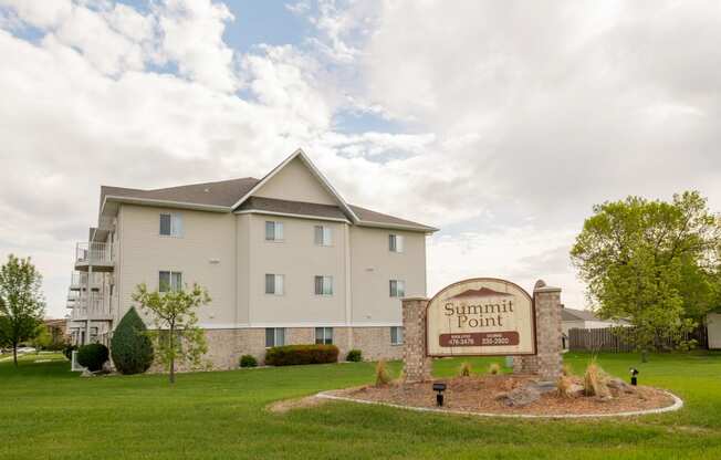 a three story apartment building with a sign out front. Fargo, ND Summit Point Apartments