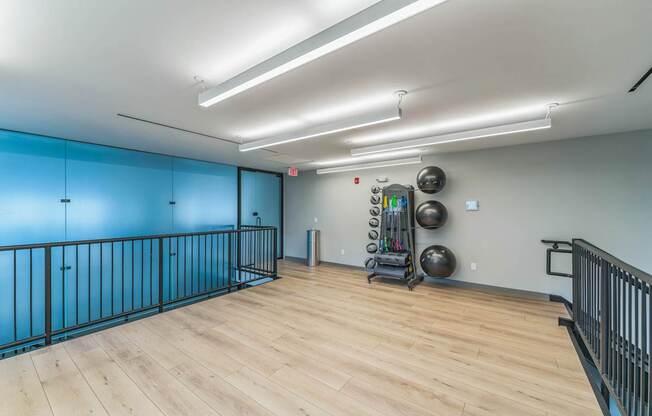 A gym with wooden floors and exercise equipment.