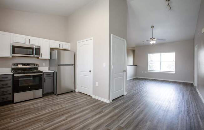 A kitchen with white cabinets and a wooden floor.