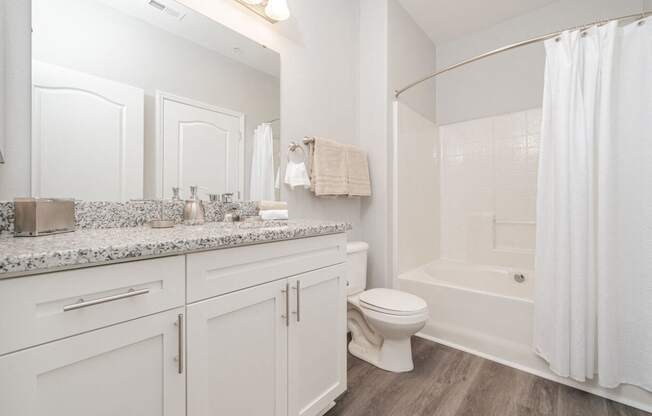 a bathroom with white cabinets and a shower and a toilet