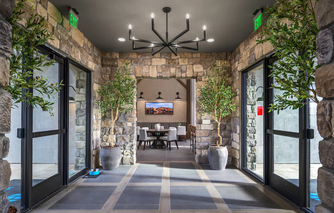 A stone wall with a TV and a table with chairs in front of it.