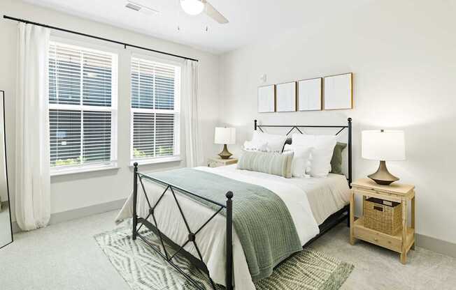 A bedroom with a bed, nightstand, and window with blinds.