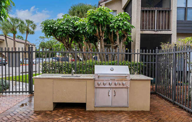 A small outdoor kitchen with a grill and sink.
