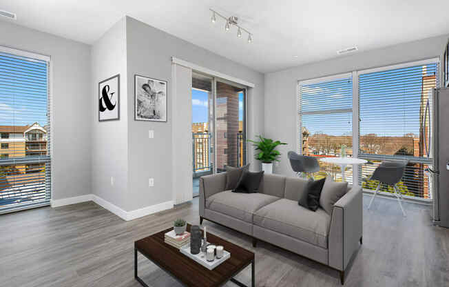 3-Bedroom Apartments in Mount Prospect, IL - 20 West - Living Room with Oversized Windows, a Private Balcony, and Grey Sofa with a Coffee Table