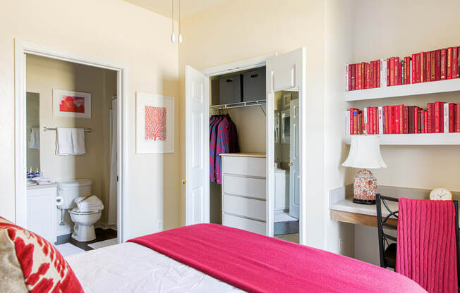 a bedroom with a bed and a bathroom in the background