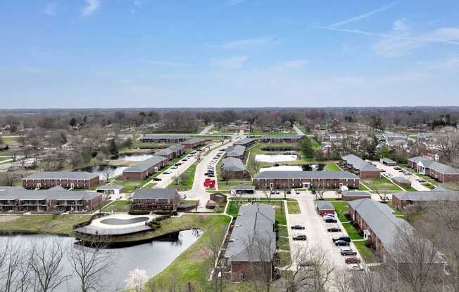 A view of a campus with a lake and buildings.