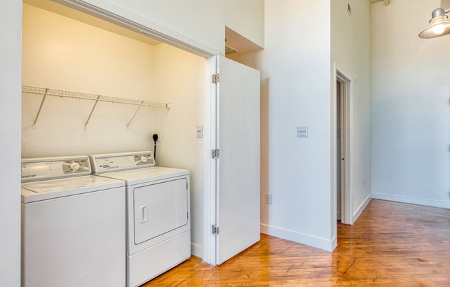 a laundry room with a washer and dryer and a door to a closet