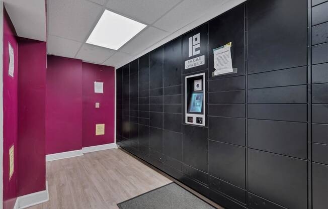 the lobby of a building with a black door and pink walls