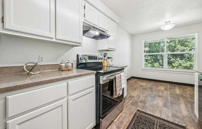 A kitchen with white cabinets and a black stove top oven.