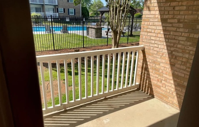 a view of a pool from a balcony with a fence