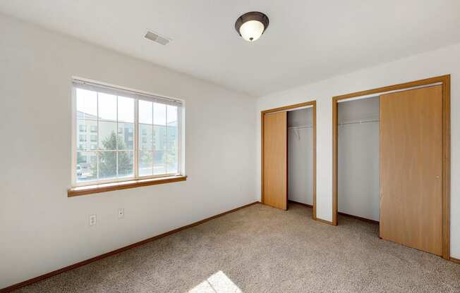 an empty living room with two doors and a window