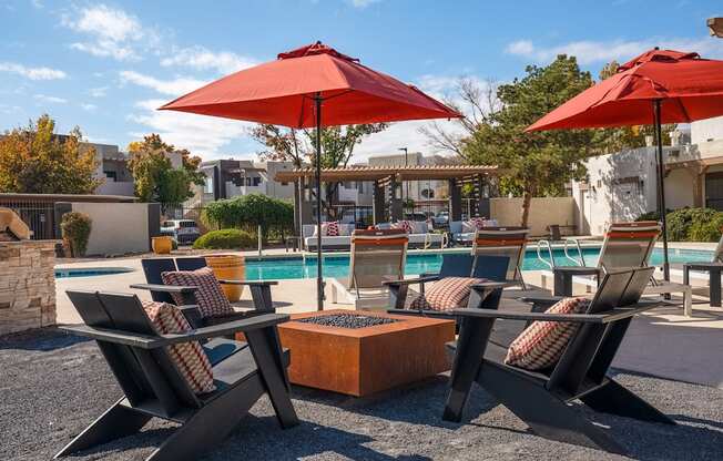 a swimming pool with chairs and umbrellas and a poolside table with chairs