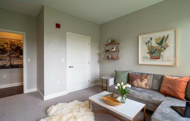 A secondary lounge or study area with a loveseat, coffee table, and tasteful artwork on the walls.