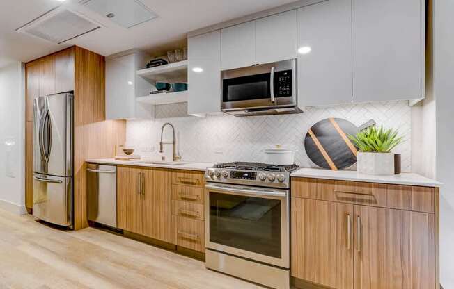A modern kitchen with wooden cabinets and stainless steel appliances.
