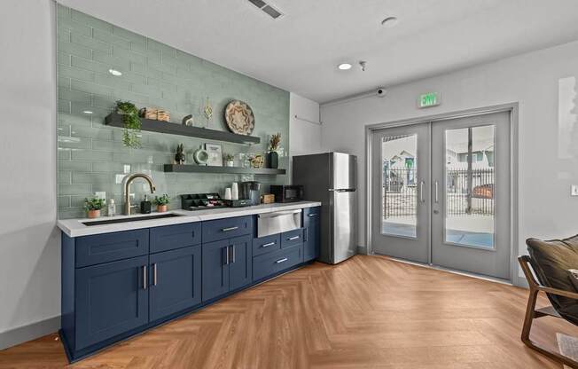 A kitchen with a blue cabinetry and a glass wall.