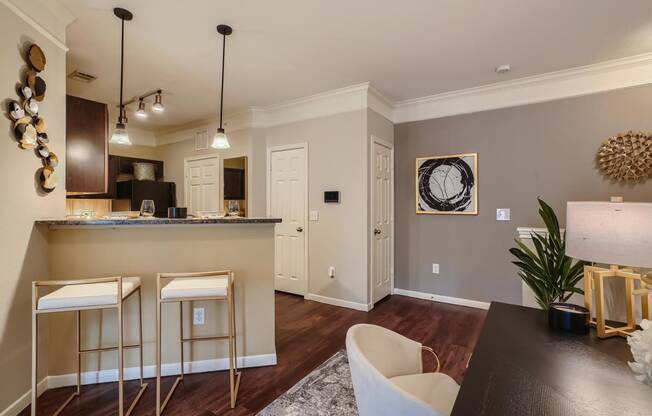 a kitchen and dining room with bar stools and breakfast bar