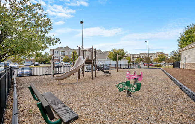 A playground with a slide, swings, and a bench.