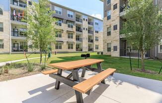 an empty park bench sitting in front of a building