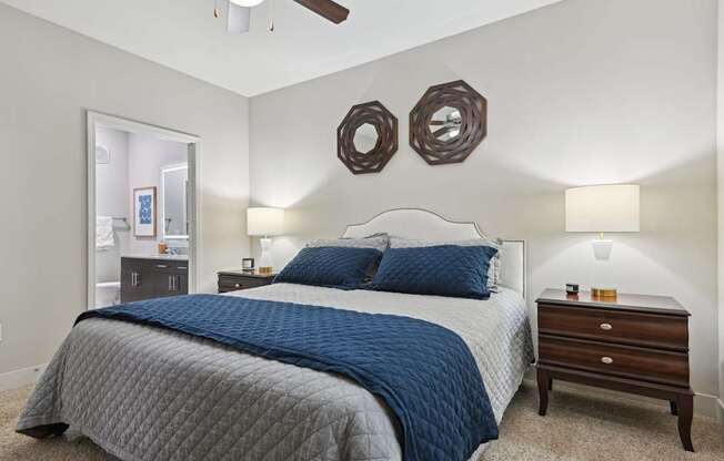 A bedroom with a bed, dresser, and mirror.