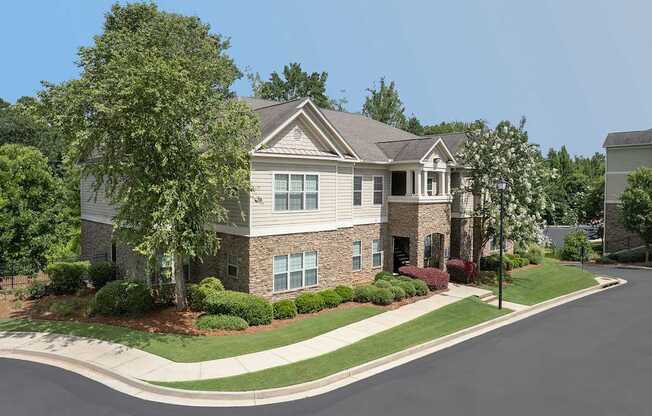 A large house with a grey roof and a driveway in front.
