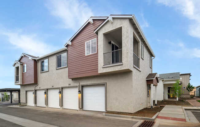 A modern two-story house with a garage and a balcony.