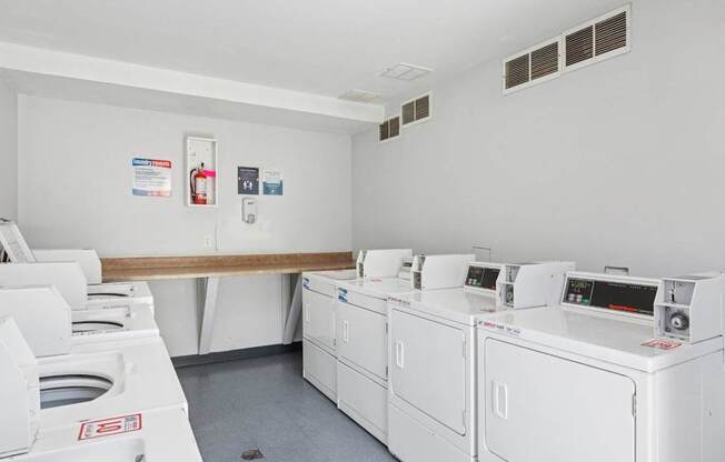 A row of washing machines in the laundry room