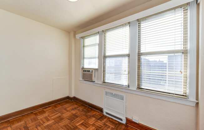 vacant bedroom with hardwood flooring, lighting and large windows at eddystone apartments in washington dc