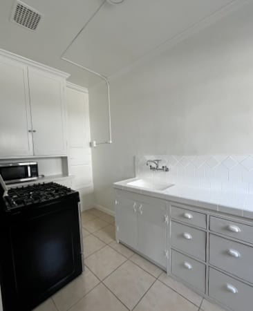 A black stove in a white kitchen with a black oven.