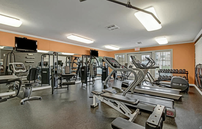 A modern fitness center here at Arbor Ridge featuring treadmills, strength machines, and free weights. Bright lighting, mirrored walls, and spacious layout create an energizing and convenient space for daily workouts.