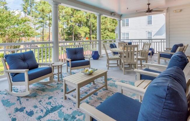 a porch with blue couches and chairs and a table at Sterling Manor, Williamsburg, 23185