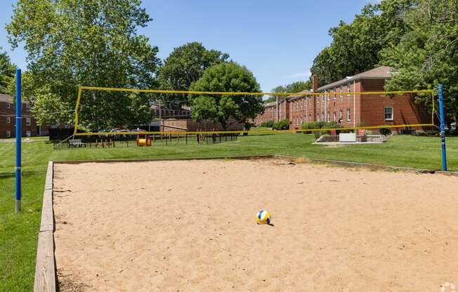 a volleyball court in front of a brick building with a volleyball