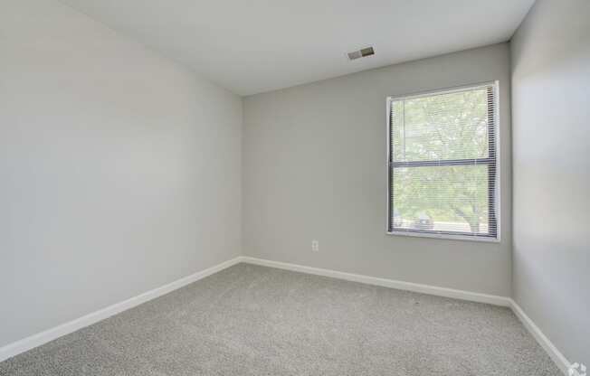 an empty room with white walls and a window