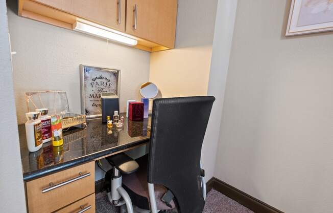 a desk with a chair in a small room with a counter top