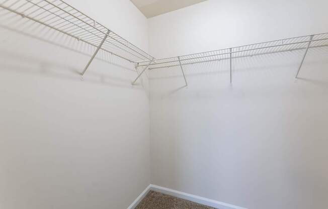 Empty room with white walls and a metal shelf.