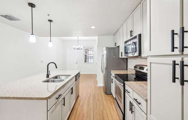 A kitchen with white cabinets and a granite countertop.