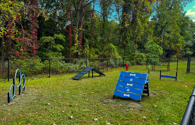 a blue bench in a park next to a skate park